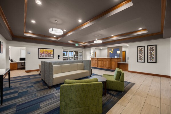 A spacious lobby with a sofa, chairs, a small table, and a kitchen area in the background. - Holiday Inn Express Hotel & Suites Limon I-70 by IHG (Limon)