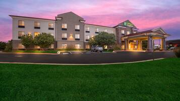 A Holiday Inn Express building with a well-lit entrance and a parking lot.