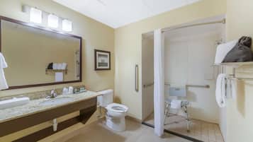 A hotel bathroom with a sink, toilet, and shower area.