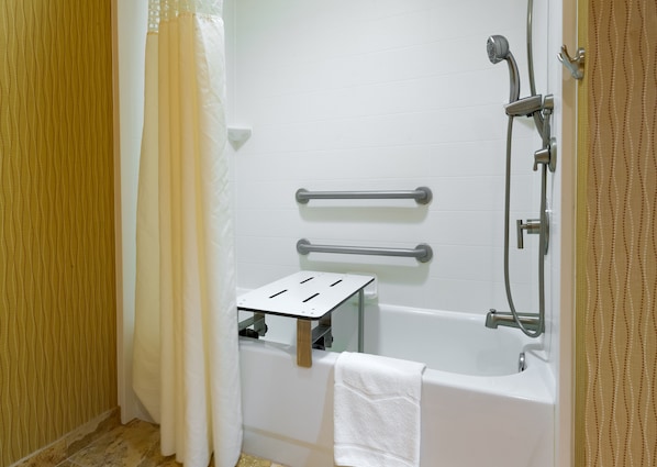 A bathroom with a bathtub, a shower, and a grab bar.