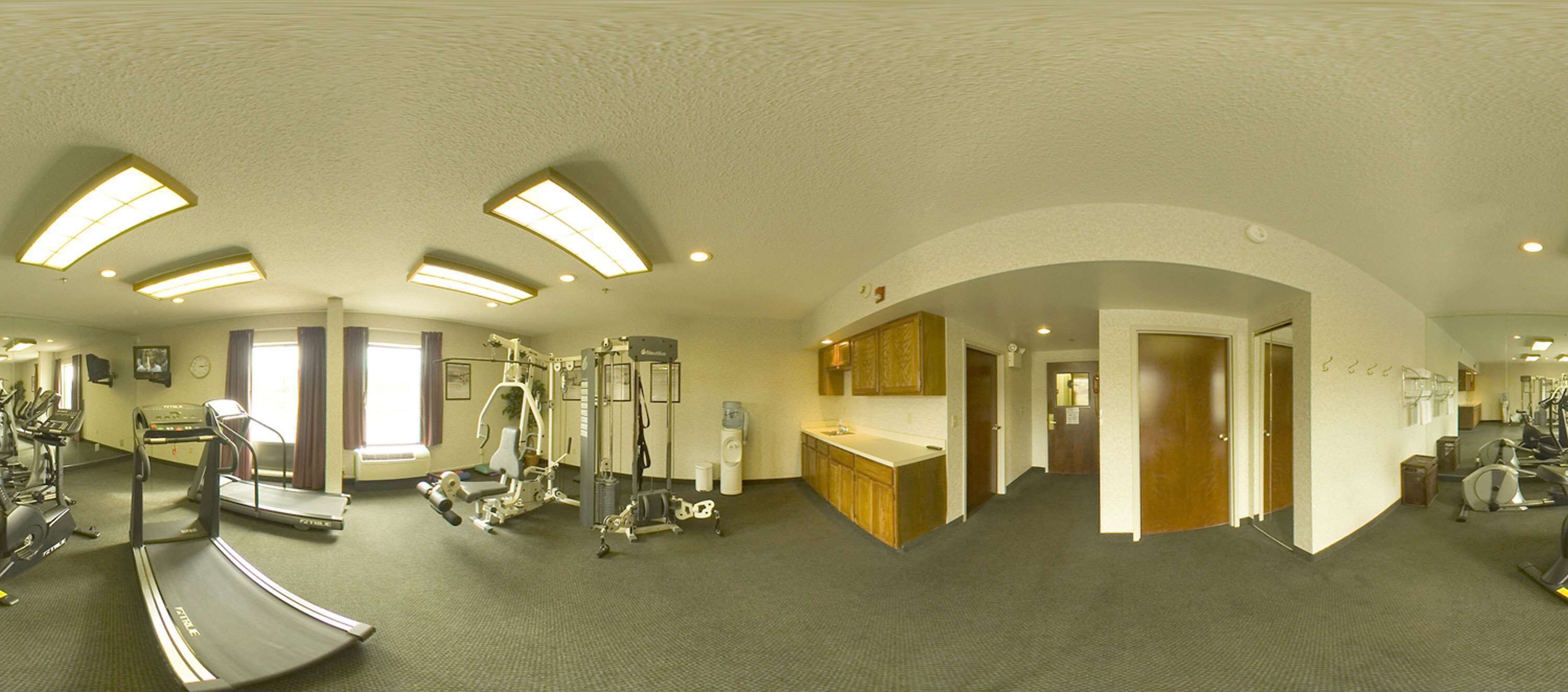 A gym with treadmills, elliptical machines, and weight equipment.