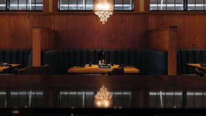 Ein Restaurant mit Holzvertäfelung, einem Kronleuchter und einem Tischschild mit der Aufschrift 'Reserviert'.