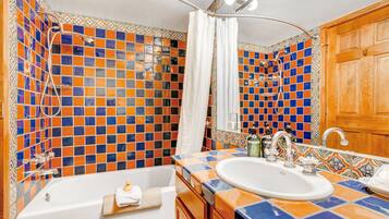A bathroom with a tiled shower, a bathtub, and a sink.