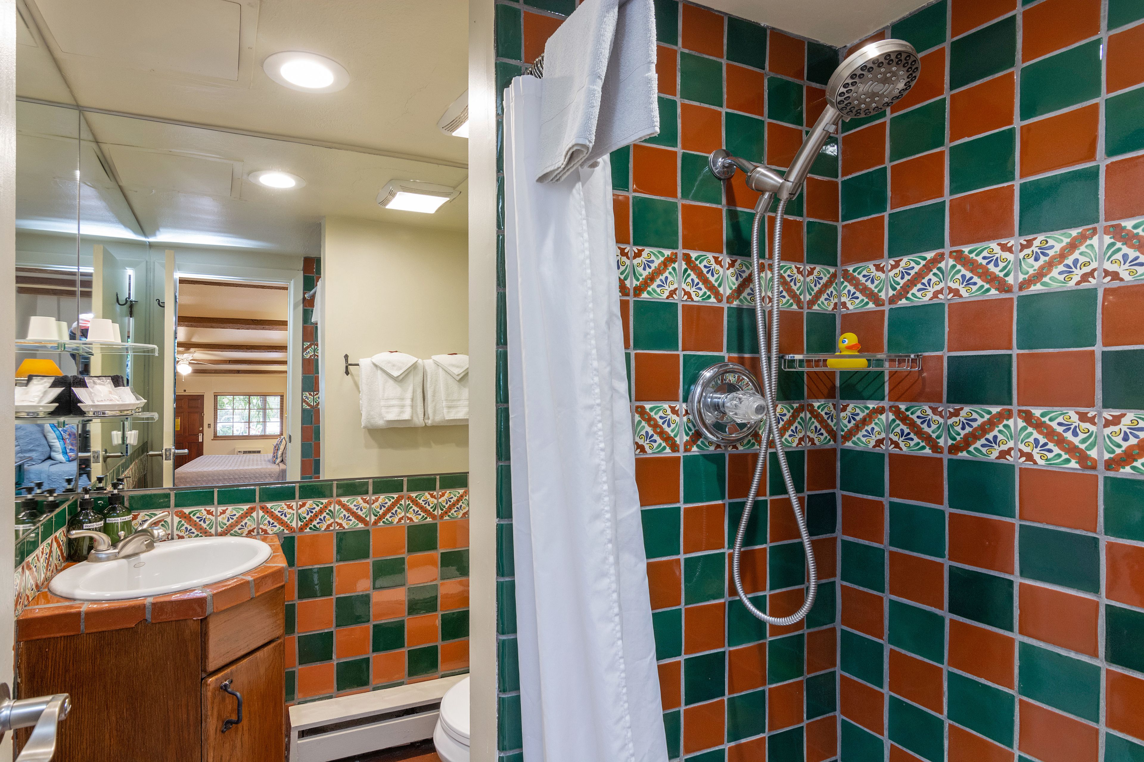 Une salle de bain avec une douche, un lavabo et un miroir.