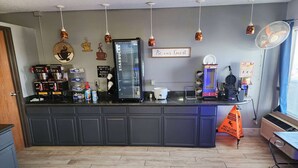 A kitchen with a coffee machine, a refrigerator, and a sign that says "Be our guest". - Super 8 by Wyndham Galesburg (Galesburg)
