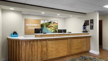 A reception desk with a 'Welcome to Hampton' sign, a 'Hulton Honors' plaque, and a 'Manager's Office' sign.