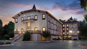 A large, historic building with a prominent tower, multiple balconies, and a well-lit entrance. - Hampton Inn Helen (Helen)