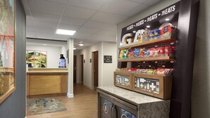 A hotel lobby with a reception desk, a snack bar, and a sign indicating the lobby and restrooms. - Hampton Inn Helen (Helen)