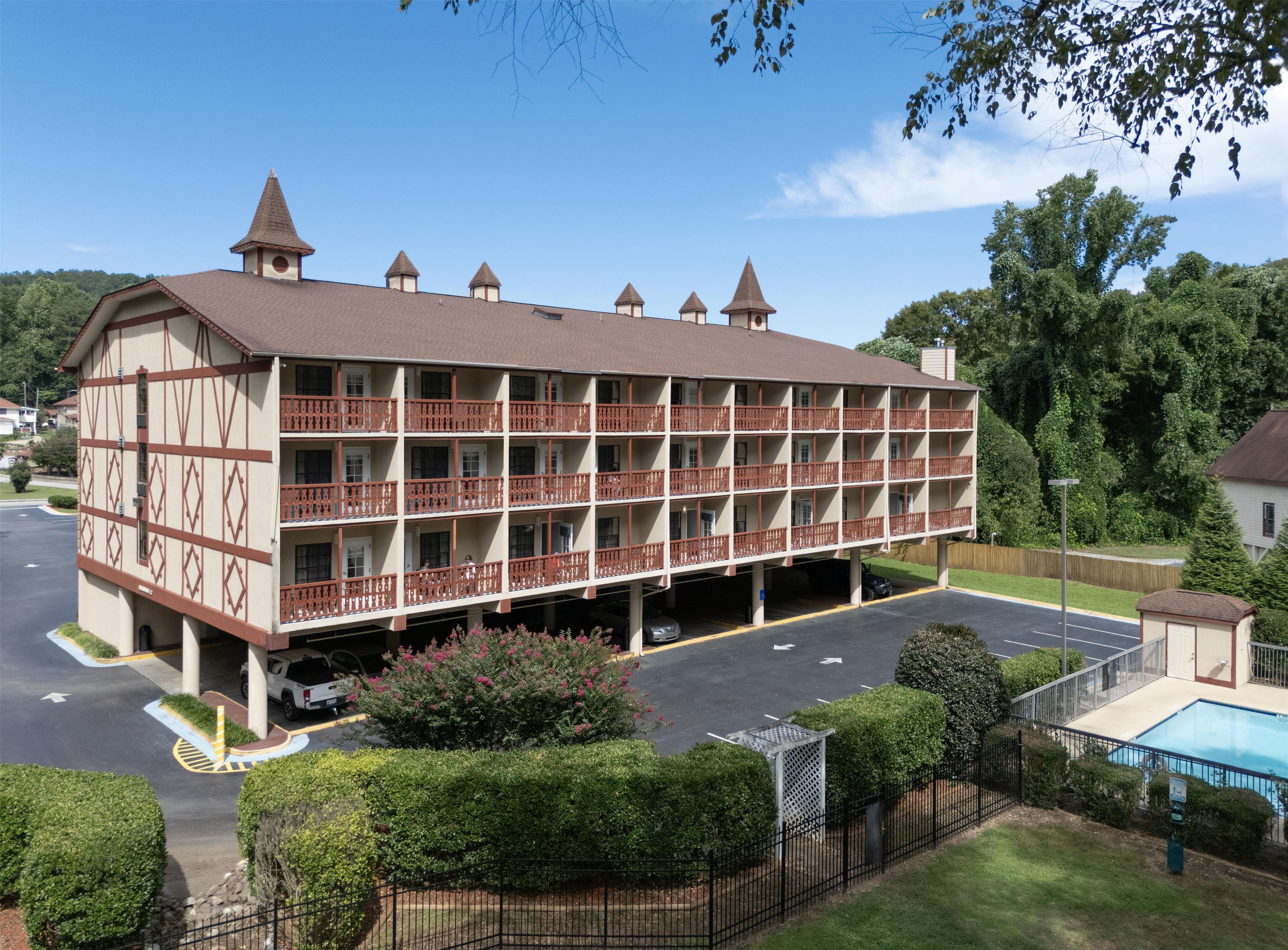 A multi-story hotel with a central courtyard and a swimming pool.