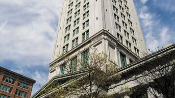 A tall, historic building with classical architecture, featuring a prominent central tower and large windows.
