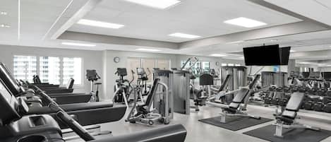 Ett modernt gym med löpband, styrketräningsmaskiner och hantlar.