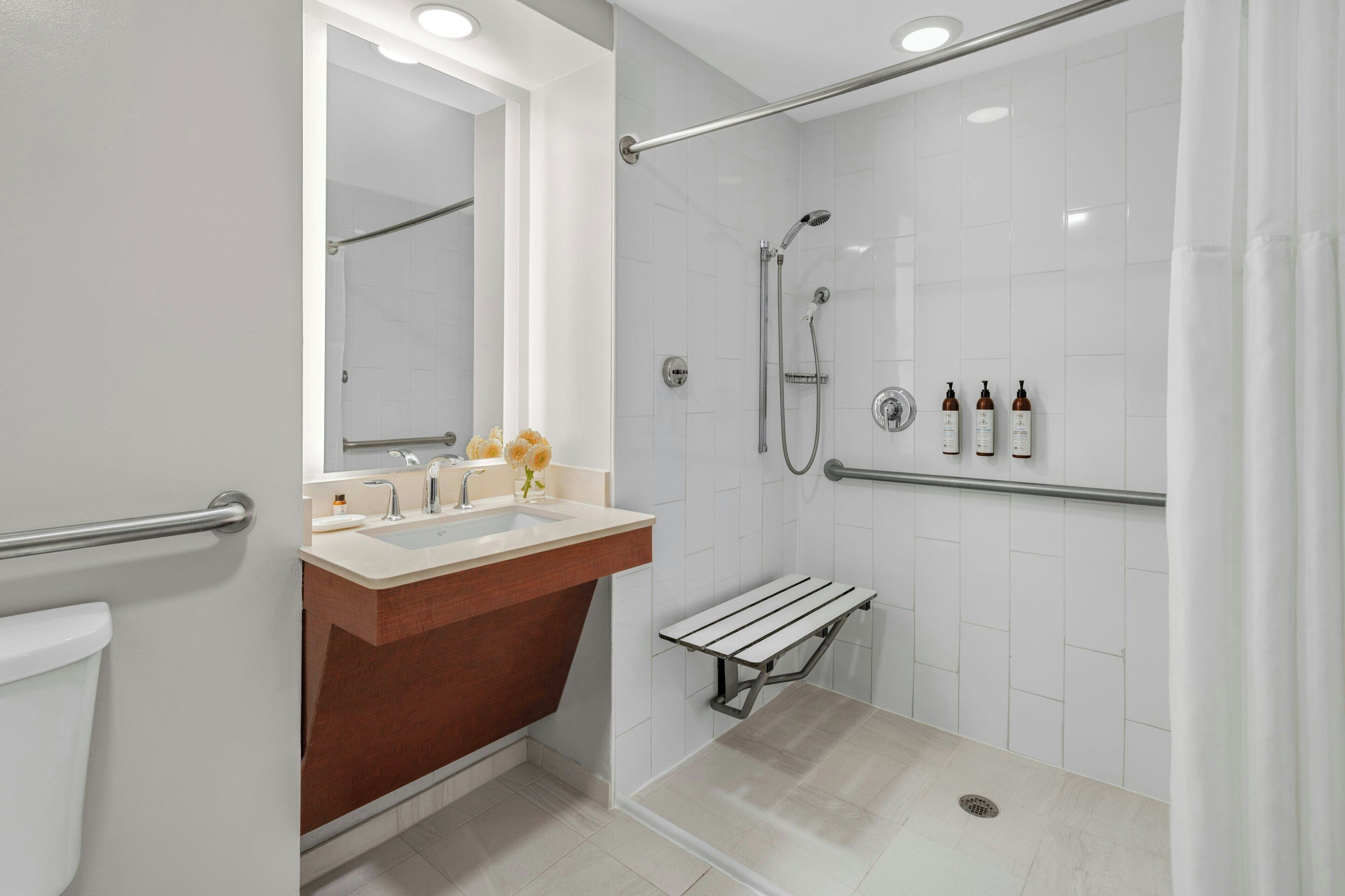 A modern bathroom with a shower, a sink, and a vanity.