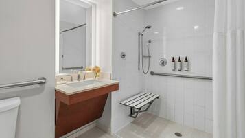 A modern bathroom with a shower, a sink, and a vanity.