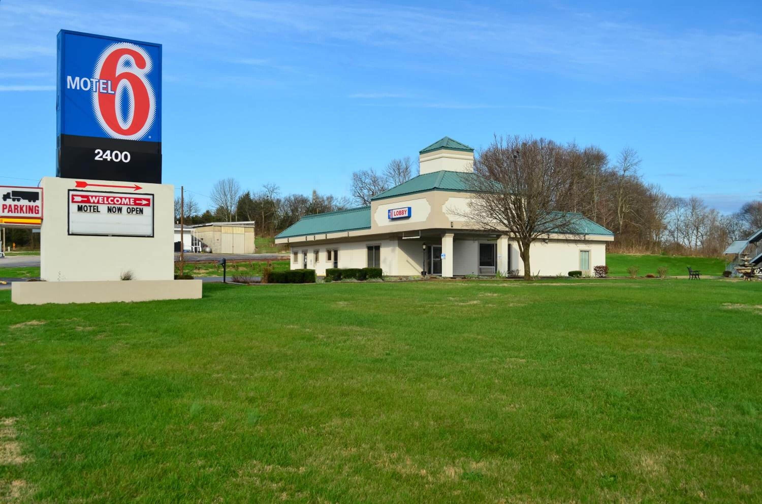 A motel with a large sign reading "Motel 6 2400" and a welcome sign.
