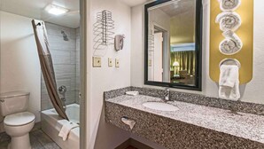 Une salle de bain avec douche, toilettes et lavabo.