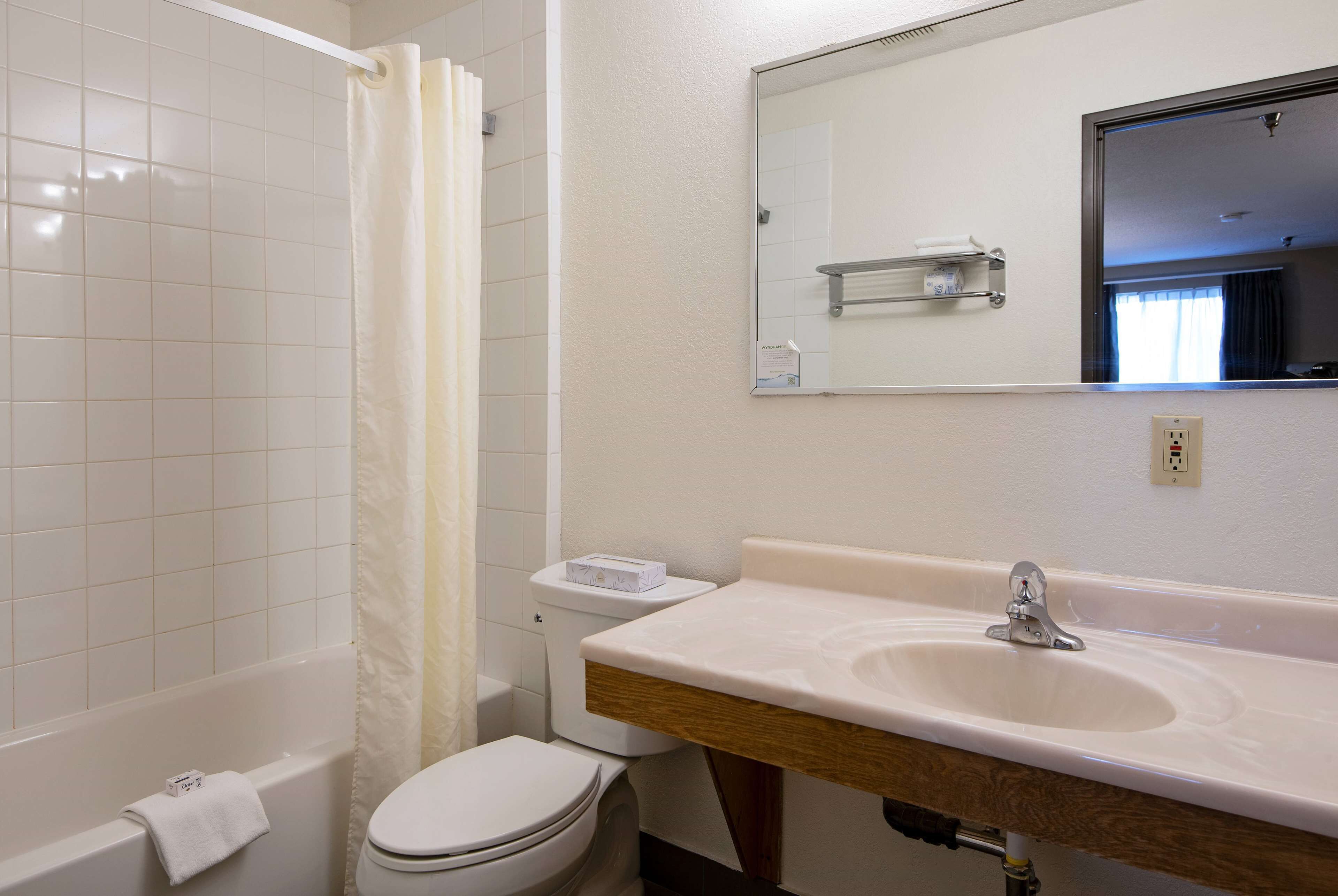 A bathroom with a bathtub, toilet, and sink.