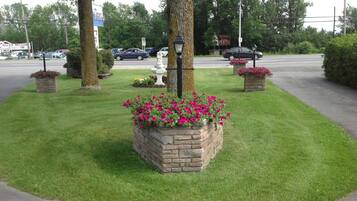 A landscaped area with a lawn, flower beds, and a street lamp.
