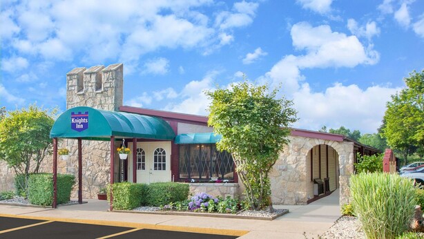 A Knights Inn with a stone facade, a green awning, and a parking lot. - Knights Inn Battle Creek (Battle Creek)