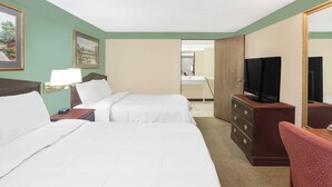 A hotel room with two beds, a TV, a dresser, and a mirror. - Knights Inn Battle Creek (Battle Creek)