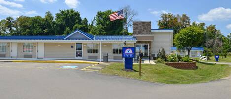 Un motel con techo azul, una bandera estadounidense y un buzón.