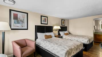Ett hotellrum med två sängar, en stol, ett skrivbord och en lampa.