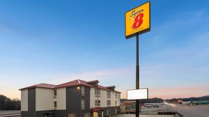 A Super 8 hotel with a parking lot and a large billboard. - Super 8 by Wyndham Chattanooga East/Hamilton Place (Chattanooga)