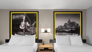A hotel room with two beds, a nightstand with a clock, wall-mounted lamps, and framed posters on the walls. - Super 8 by Wyndham Chattanooga East/Hamilton Place (Chattanooga)
