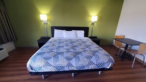 A hotel room with a bed, two bedside tables, a desk, and a chair. - Motel 6 Chilhowie, VA  I-81 (Chilhowie)
