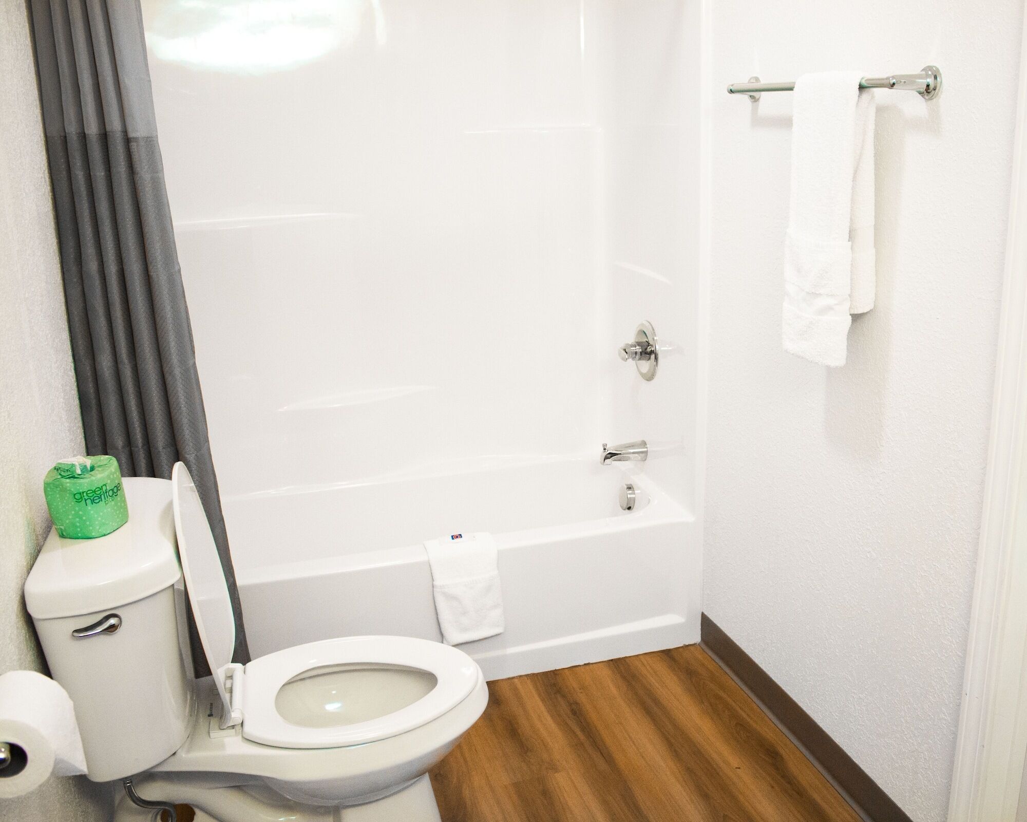 A bathroom with a toilet, a bathtub, and a shower curtain.