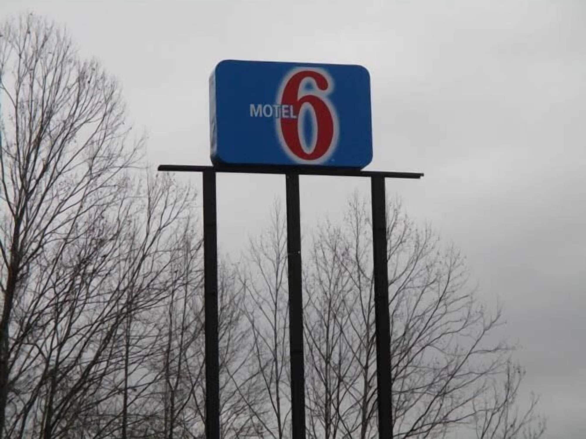 Letrero de motel con el número 6 sobre un fondo azul.