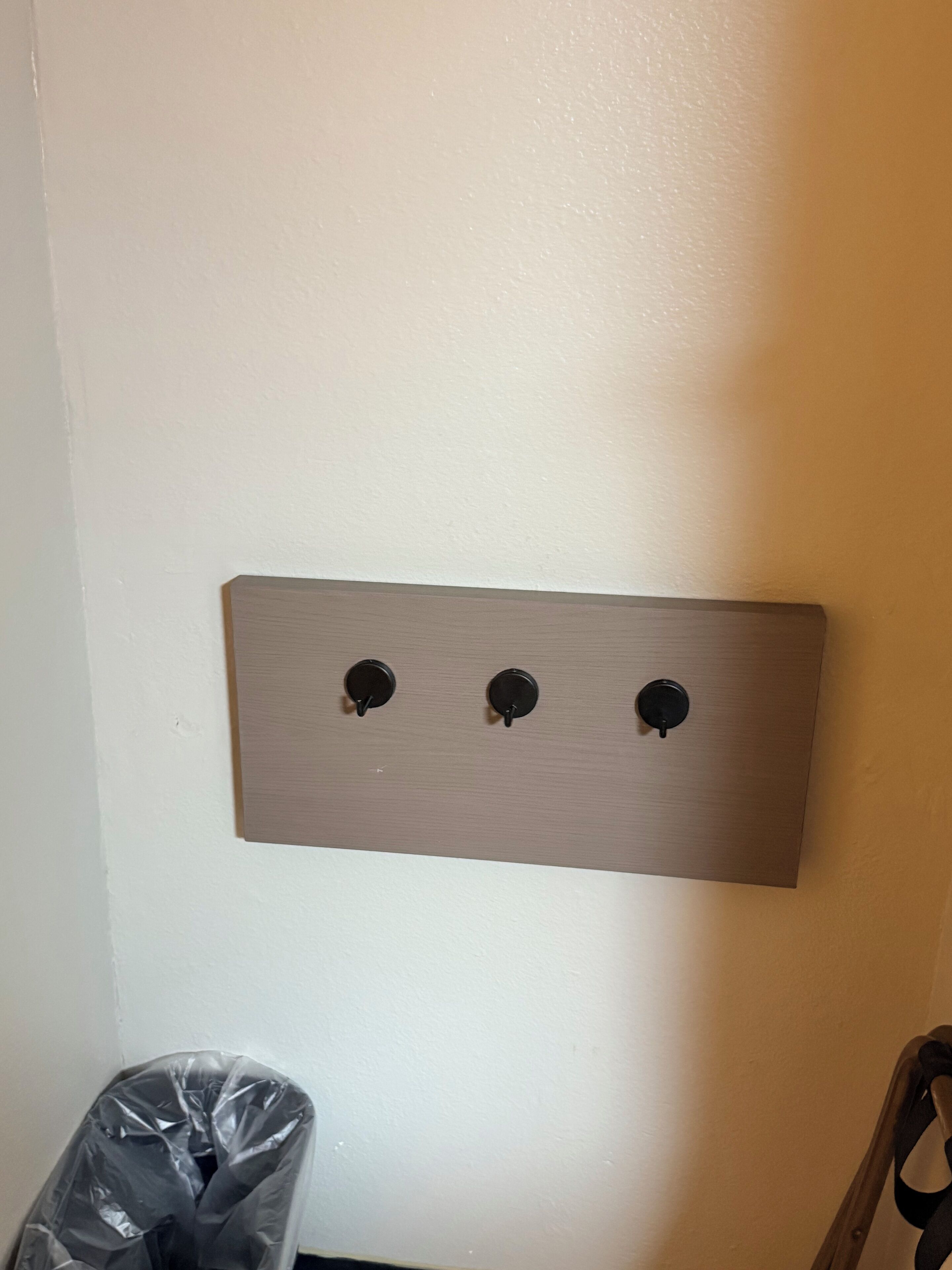 A wall-mounted light switch panel with three switches.