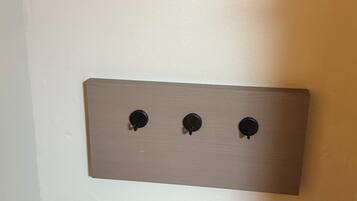 A wall-mounted light switch panel with three switches.