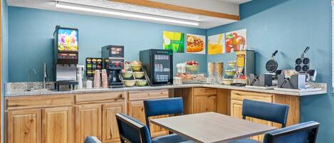 A breakfast bar with seating, a refrigerator, and a microwave.