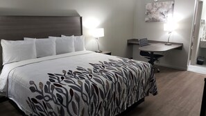 A hotel room with a bed, bedside lamps, a desk, and a chair.
