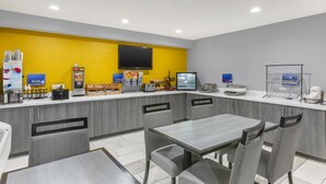 A modern breakfast area with a counter, seating, and a TV.