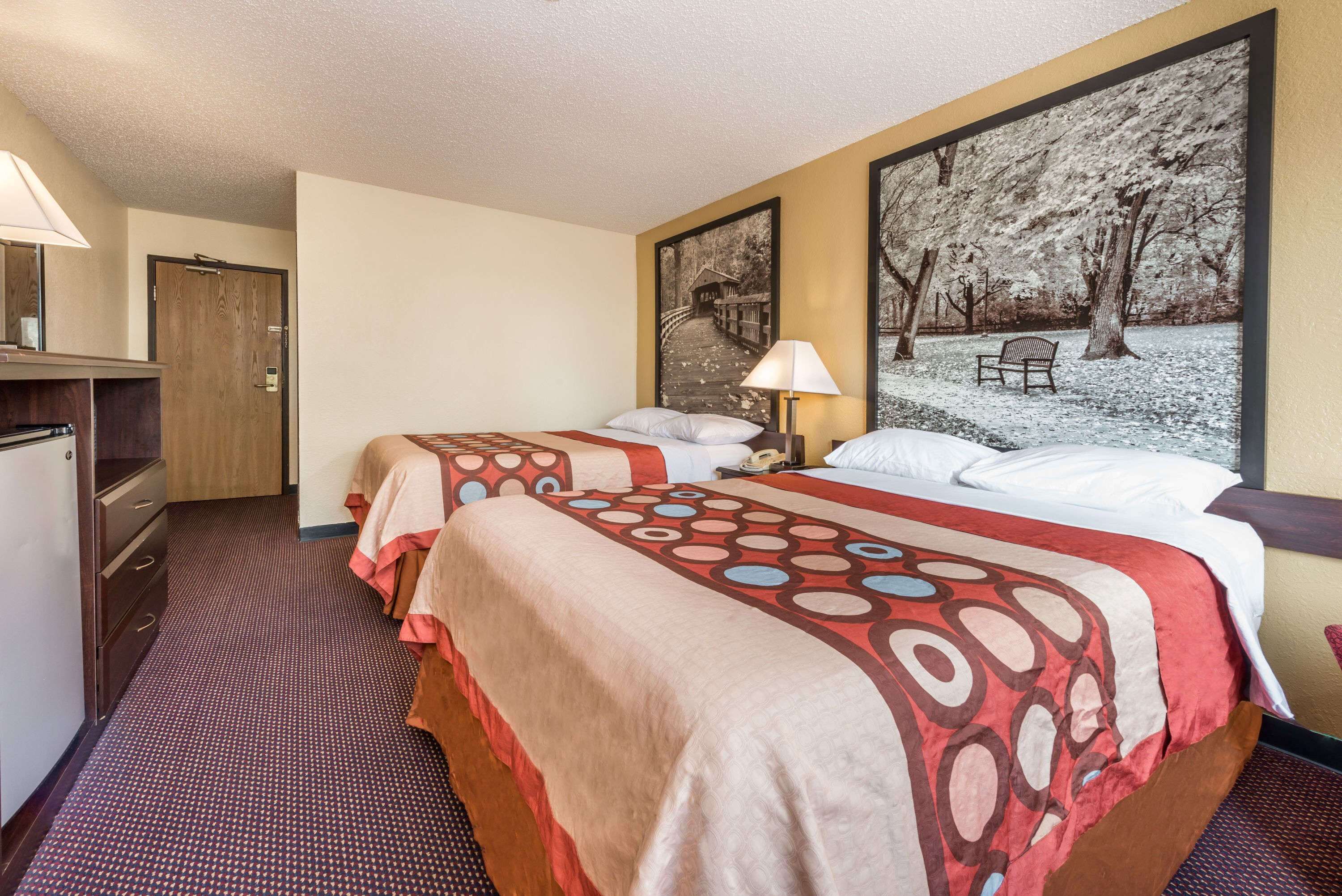 Una habitación de hotel con dos camas, un escritorio y un armario.