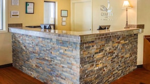 A reception area with a stone counter, framed certificates on the wall, and a sign indicating the manager is on duty.