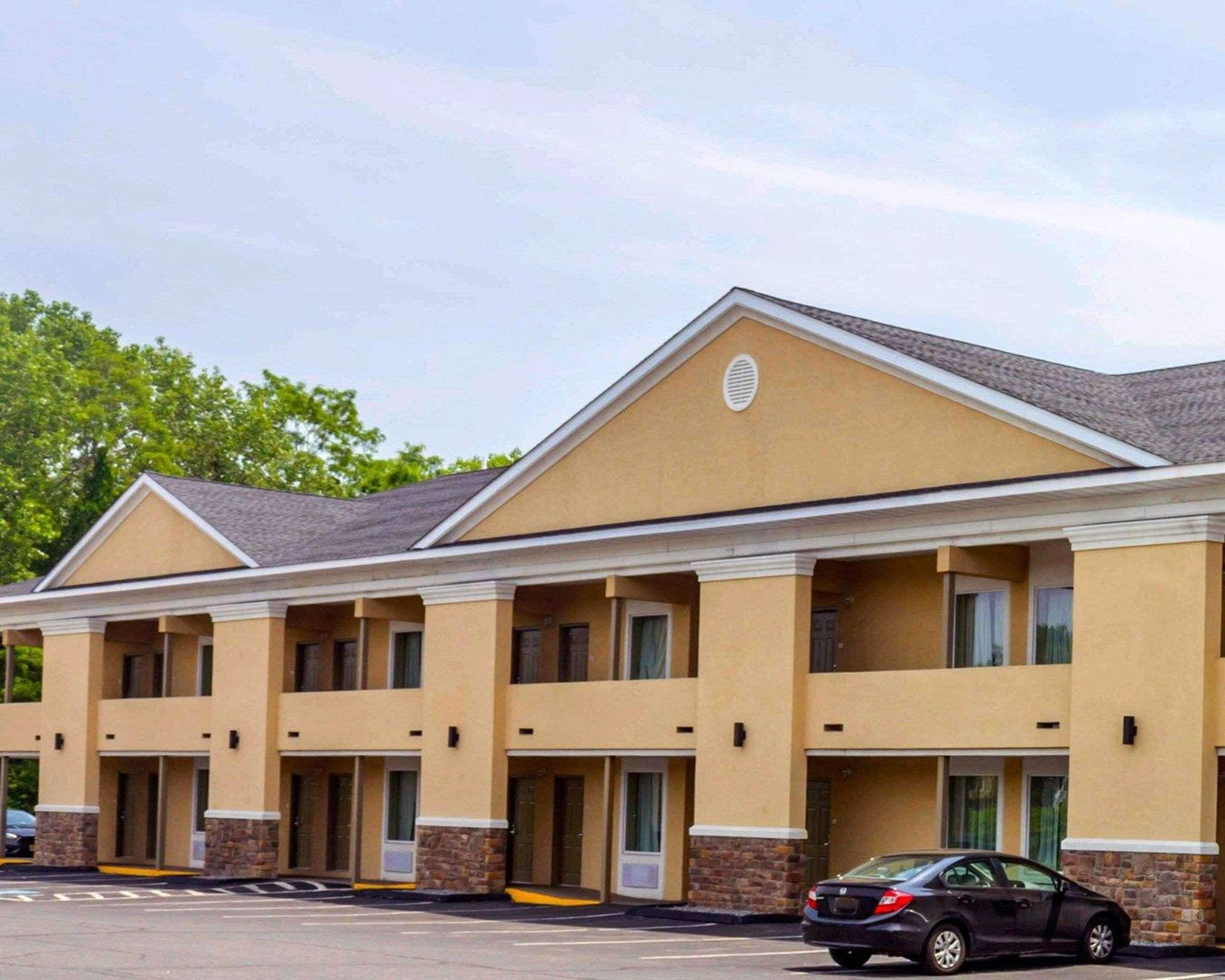 A hotel with a row of single-story rooms, each with a door and a small porch.