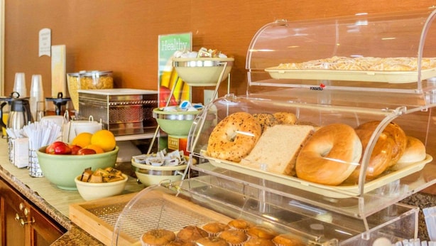 A breakfast buffet with various food items, including pastries, bread, and fruits.