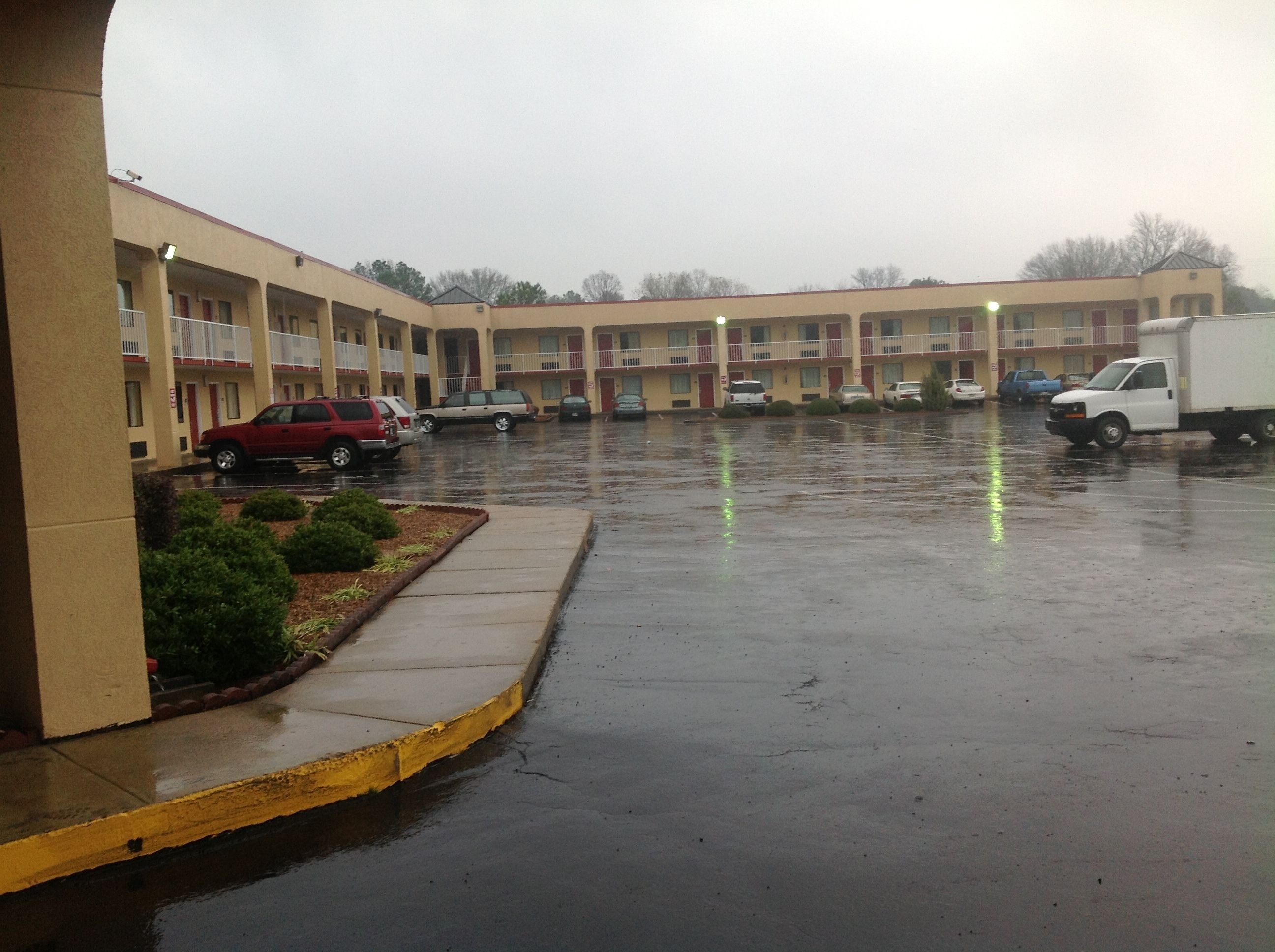 A multi-story motel with a parking lot.