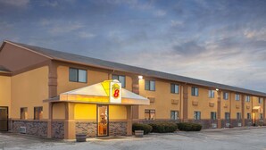 Un hotel con un llamativo letrero de 'Sofitel', fachada de ladrillo y un estacionamiento.