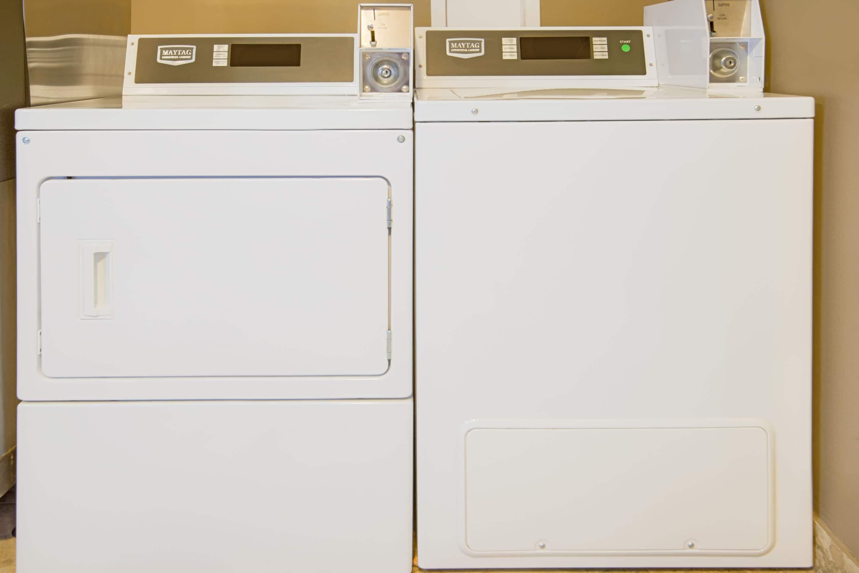 Two white Maytag washing machines side by side in a room.