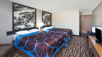 Una habitación de hotel con dos camas, televisión, escritorio y obras de arte en las paredes.