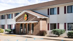 A motel with a prominent Super 8 sign, a brick facade, and a parking lot.