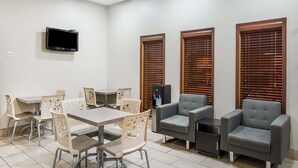 A modern meeting room with a table, chairs, and a television.