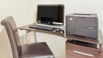 Een bureau met een laptop, toetsenbord en een HP-printer.
