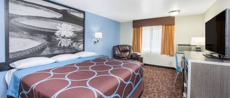 A hotel room with a large bed, a desk with a television, and a wall-mounted TV.