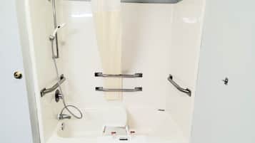 A shower with a handheld showerhead, a towel rack, and a soap dish.