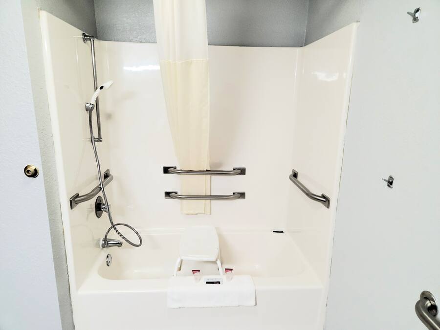 A shower with a handheld showerhead, a towel rack, and a soap dish.