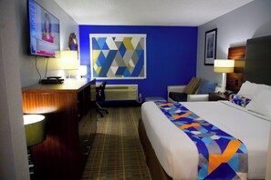 A hotel room with a bed, desk, and TV. - Express Inn Parsons (Parsons)